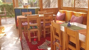 A wooden interior with a long red carpet, wooden furniture, and large windows. - A soothing guest house set in nature and on the beach of the Atlantic coast (Essaouira)