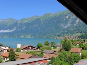 A residential area with houses, a lake, and mountains in the background.