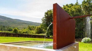 Una fuente rectangular con estructura metálica y efecto cascada.