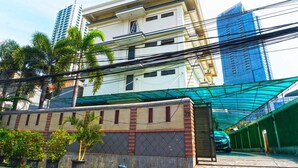 A multi-story building with a flat roof and a green awning.