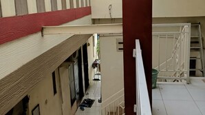 A multi-level building with a covered outdoor area, tiled floors, and a staircase.