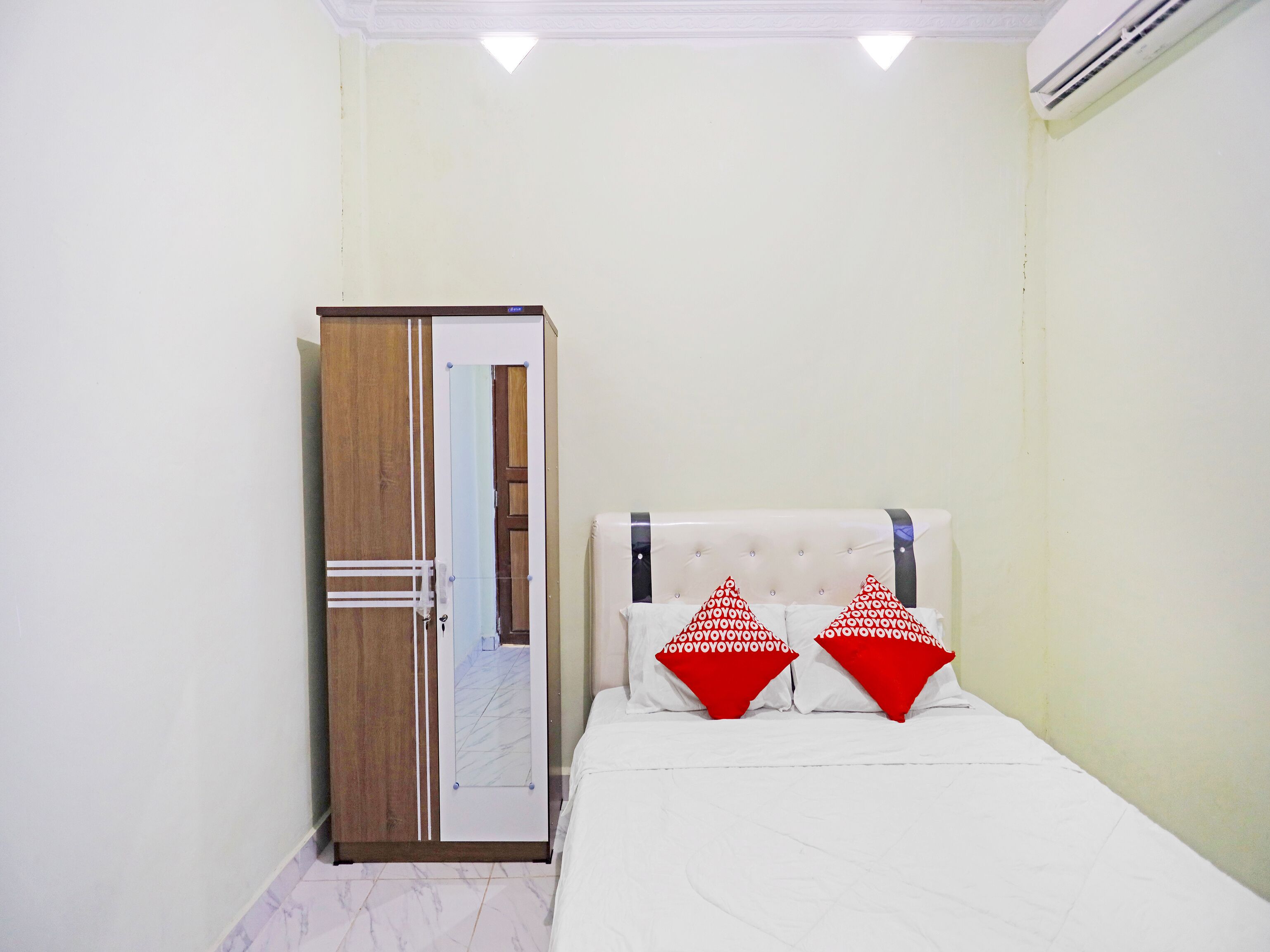 Quarto com uma cama, um guarda-roupa e uma porta.