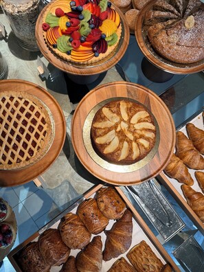 A variety of baked goods including pies, tarts, and pastries displayed on wooden platters. - La Suera San Pantaleo (Olbia)