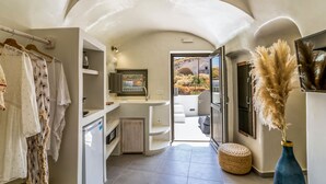 Cocina moderna con refrigerador integrado, lavamanos y ventana con vistas a un espacio exterior pintoresco.