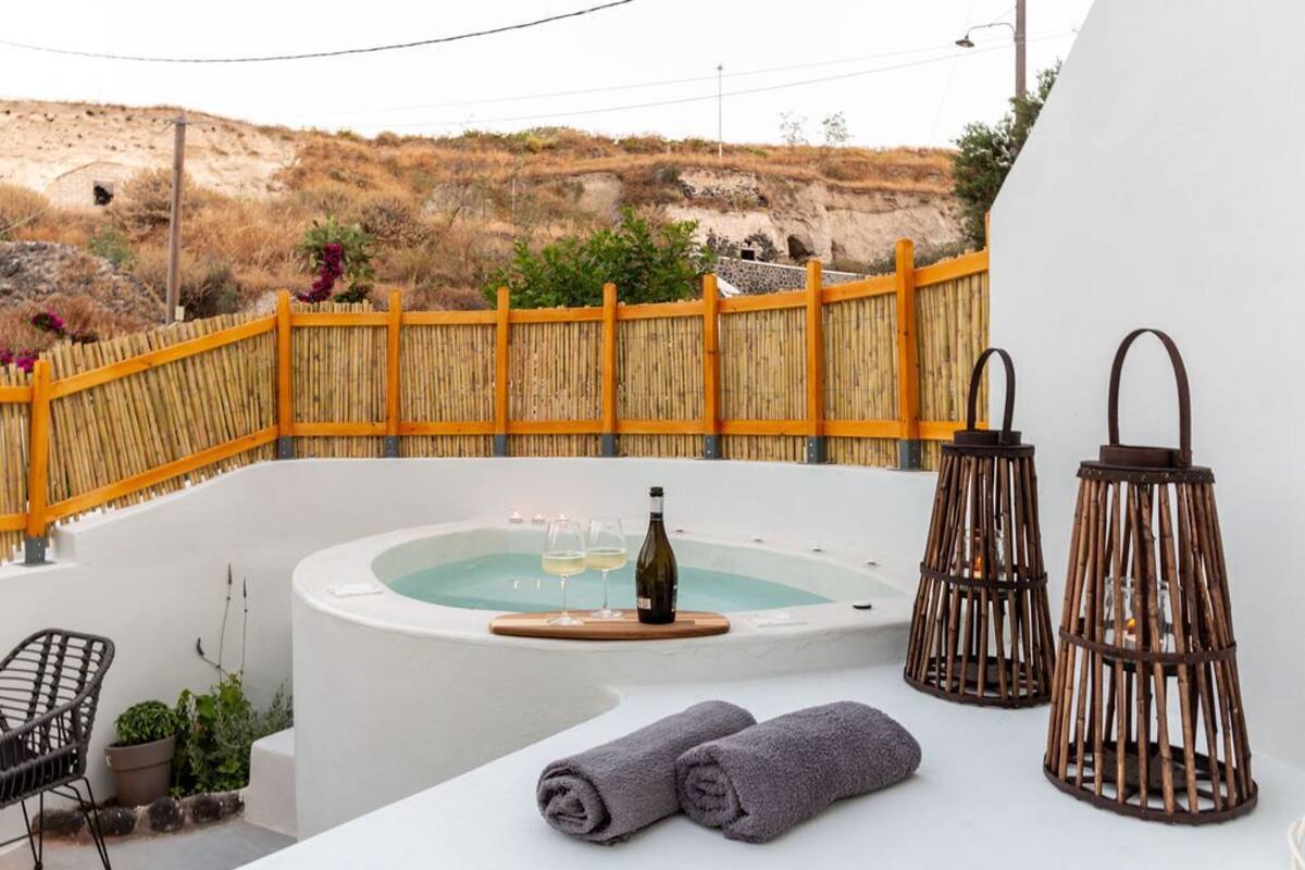 Un área de spa con un jacuzzi, dos toallas y dos faroles con velas.