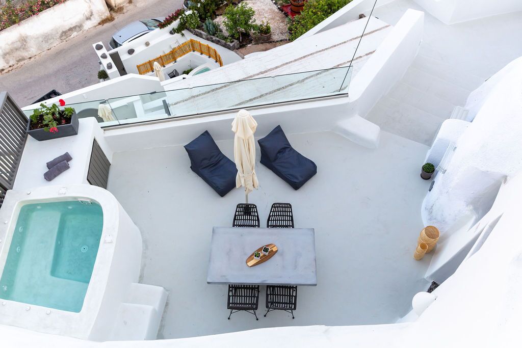 Terraza en la azotea con piscina, zona de estar y mesa.
