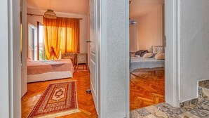 A bedroom with a bed, a nightstand, a lamp, and a window with curtains.
