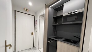 Une cuisine moderne équipée d’un lave-vaisselle encastré, d’un four à micro-ondes et d’un meuble en bois.