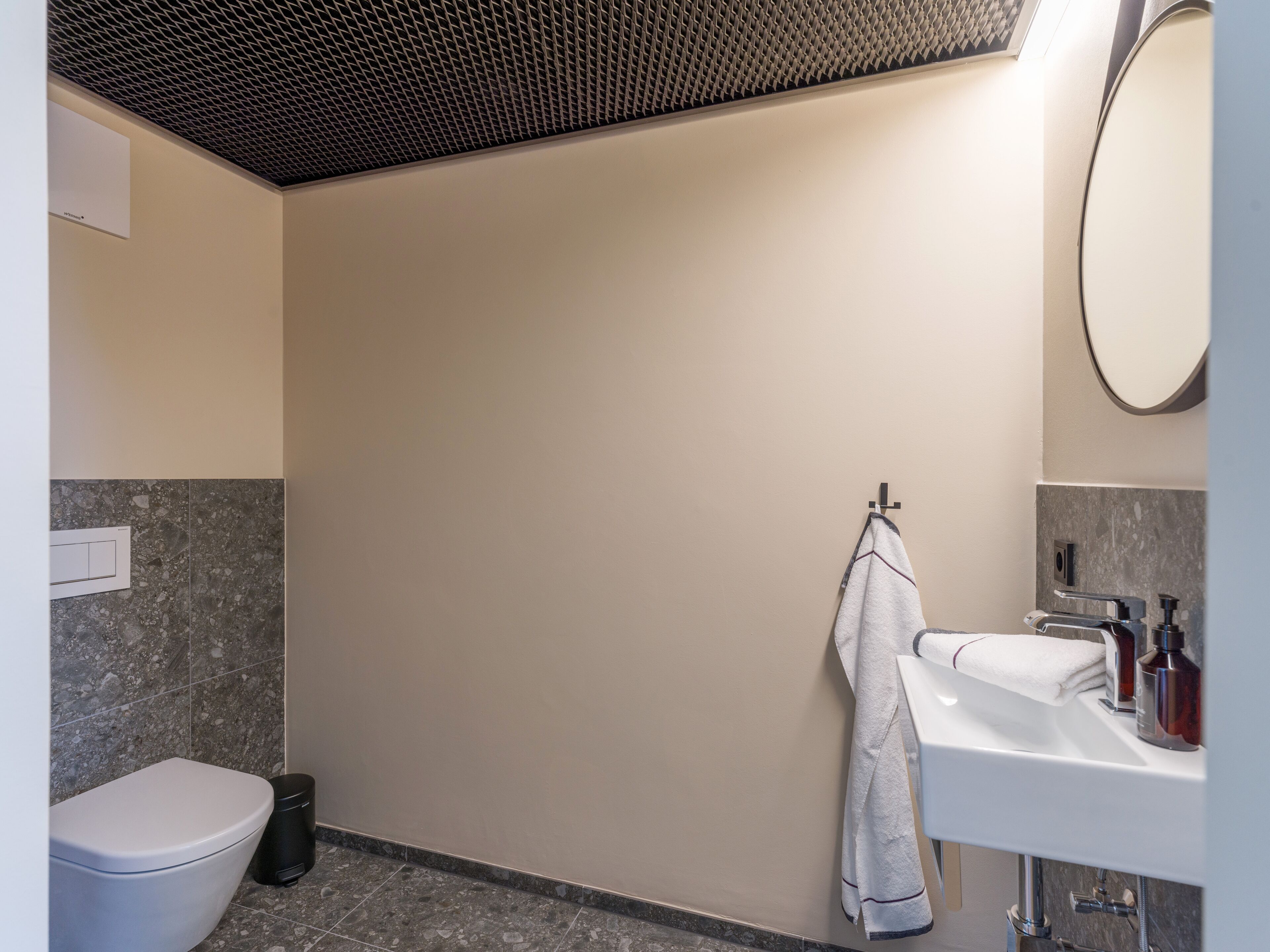 Ein modernes Badezimmer mit Toilette, Waschbecken und Handtuchhalter.