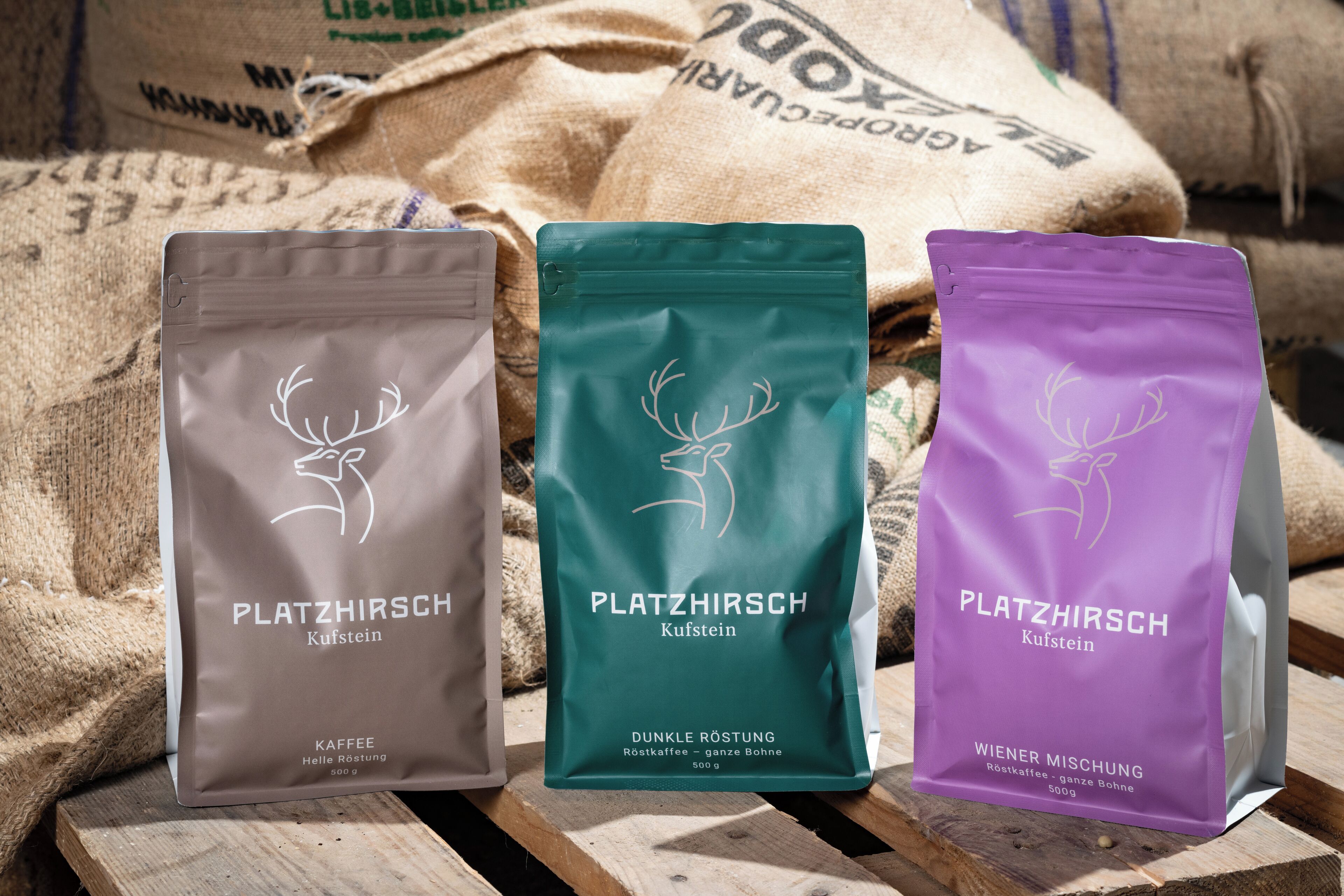 Trois sacs de café de la marque « Platzhirsch », avec différents types de torréfaction.