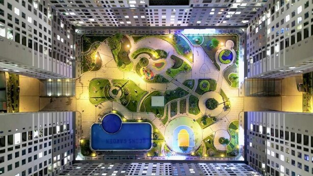 A modern building with a unique rooftop garden design, featuring winding pathways and green spaces. - Bcons Garden Luxury Apartment (Ho Chi Minh City)