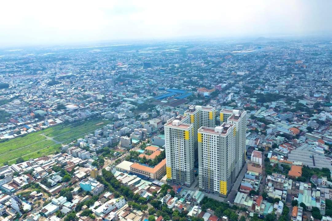 Ein Hochhaus mit mehreren Stockwerken, umgeben von einer dicht bebauten Stadt mit verschiedenen Gebäuden und Straßen.