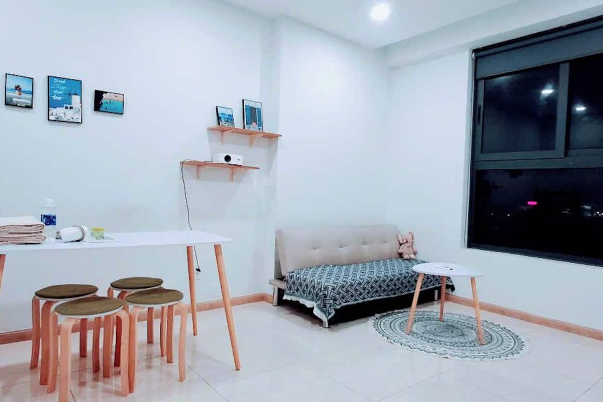 Une pièce comprenant un lit, un bureau avec des chaises, une fenêtre et des éléments de décoration murale.