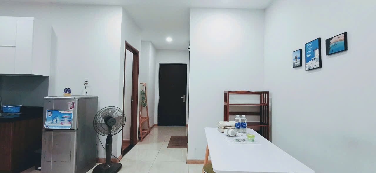 A hotel room with a kitchenette, a dining area, and a bed.