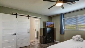 A bedroom with a bed, a dresser, a ceiling fan, and a window with blinds. - Gorgeous Scottsdale Home w/ Heated Pool (Scottsdale)