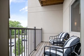 Enjoy the view from this balcony with a bathtub and two comfortable chairs.