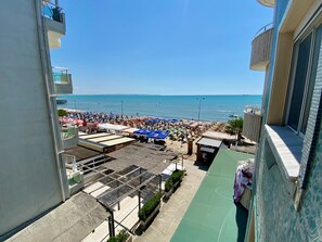 A beachside view from a balcony overlooking a crowded beach with umbrellas and sun loungers. - Modern residence a few steps from the Adriatic Sea (Durrës)