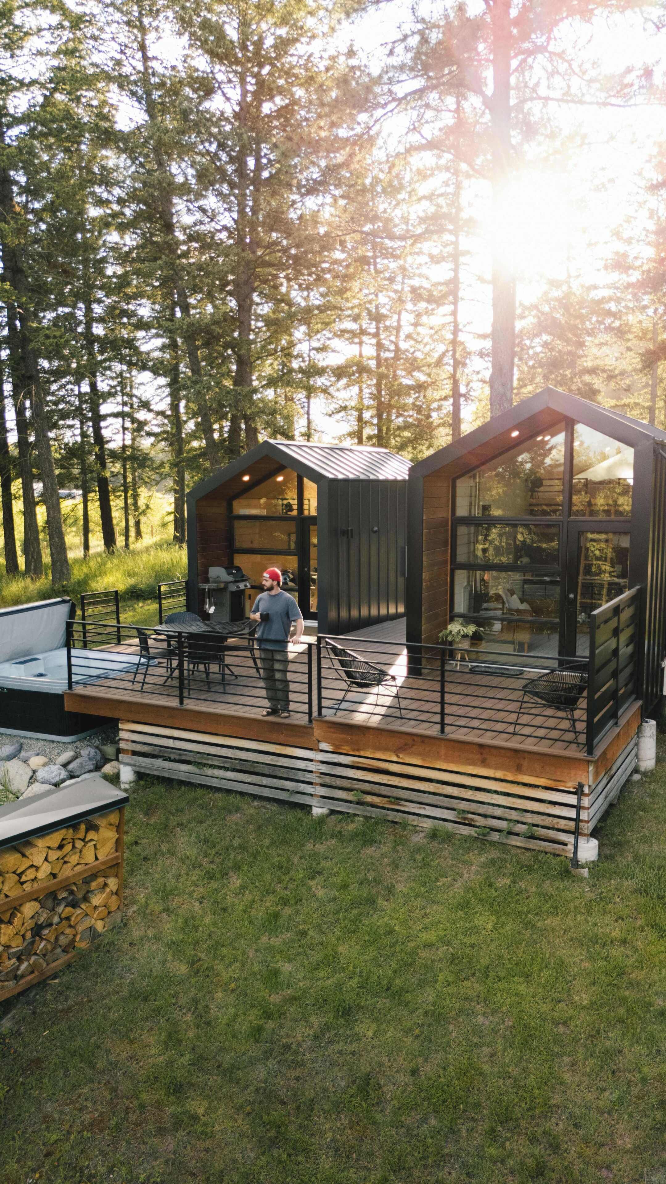 Une cabane moderne dotée d’une terrasse, d’un espace salon extérieur et d’un coin barbecue.