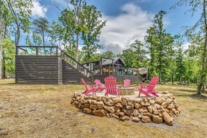 A cabin with a deck, outdoor seating, and a stone fire pit. - The Dolly House at The Retreat at Water's Edge (Tracy City)