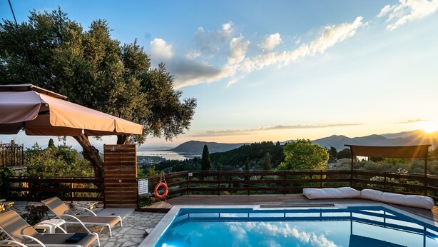 A swimming pool with lounge chairs, a wooden deck, and a view of the landscape. - Apartment 'Yakinthos' with Sea View, Wi-Fi and Air Conditioning (LEFKADA)