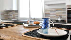 A breakfast setting with a coffee cup, plate, and utensils on a woven placemat. - Appartamento Prato al Mare with Garden, A/C & Wi-Fi (Cala Gonone)