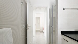 A hallway with a white towel, a glass shower enclosure, and a black countertop. - Appartamento Prato al Mare with Garden, A/C & Wi-Fi (Cala Gonone)