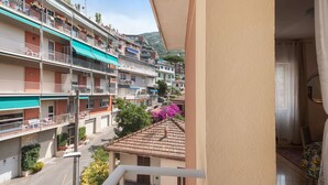 Un edificio residencial con varios balcones, vista a la calle y una montaña al fondo.