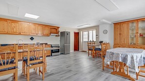 A spacious kitchen with wooden cabinets, a refrigerator, and a dining area with a table and chairs. - Holiday Home Casa Carmencita with Sea Views, Pool and Wi-Fi (La Garita)