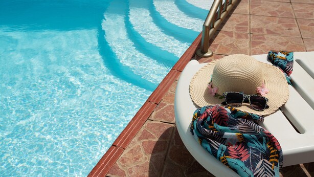 A pool with clear water, a white lounge chair, a straw hat, sunglasses, and a colorful towel. - Holiday Home Casa Carmencita with Sea Views, Pool and Wi-Fi (La Garita)