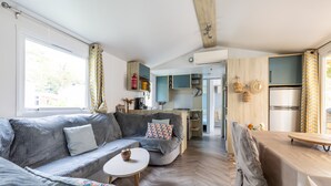 Eine moderne Küche mit Holzausstattung, einem Esstisch und einer Couch in einem hellen Wohnbereich mit Fischgrätparkett.