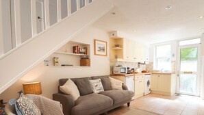 A cozy living room with a sofa, a small table, and a bookshelf.