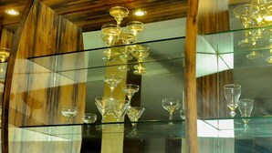 A glass display case with various wine glasses and a wine bottle. - Hotel Aruni Ancol (Jakarta)