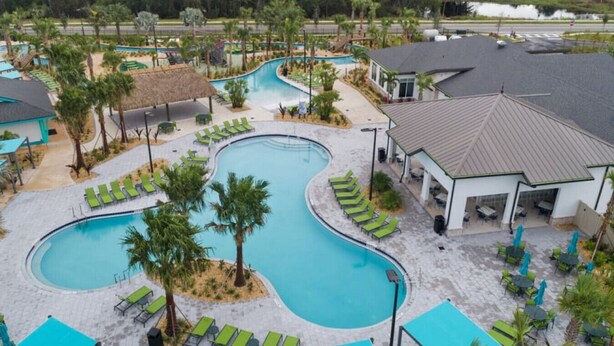 A resort with a large pool, lounge chairs, and a gazebo. - 205 Luxury condo at Storey lake (Kissimmee)
