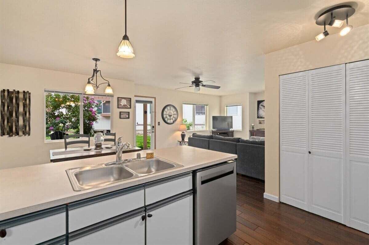 Eine moderne Küche mit Geschirrspüler, ein Essbereich mit Tisch und Stühlen, ein Wohnzimmer mit Sofa und ein großer Kleiderschrank.