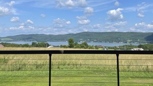 A view of a lake with surrounding hills and a clear sky.