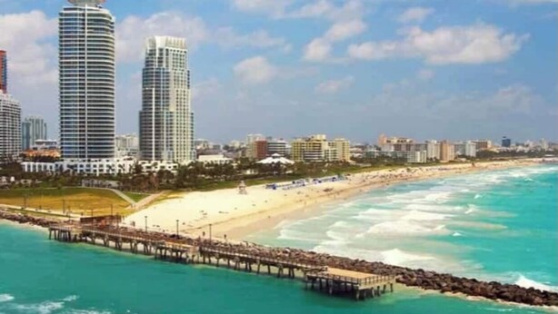 A coastal cityscape with a beach, a pier, and high-rise buildings. - Beautiful Miami Pool Lake Studio (Cutler Bay)