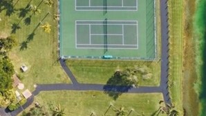An aerial view of a sports complex with a tennis court, a baseball field, and surrounding greenery. - Beautiful Miami Pool Lake Studio (Cutler Bay)