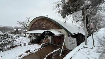 Un edificio cubierto de nieve con un cartel que anuncia el Medicine Park Music Hall & Event Center, indicando que alberga bodas, recepciones, banquetes y eventos corporativos.