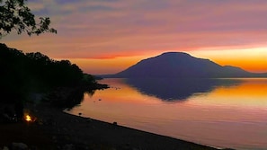 Un lago tranquilo al atardecer con una montaña al fondo.