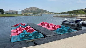 Eine Anlegestelle mit Tretbooten und einem am Steg vertäuten Boot.