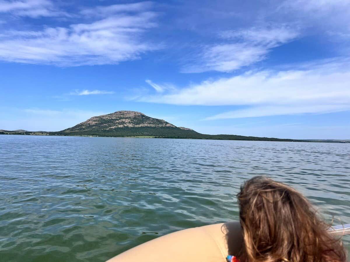A boat on a lake with a mountain in the background.