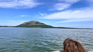 A boat on a lake with a mountain in the background.
