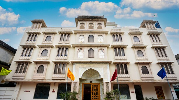 A large, multi-story building with a symmetrical facade, multiple windows, and a central entrance with a decorative arch. - Maru Casa A City Center Hotel (Jaipur)