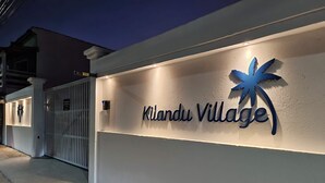 Una entrada tancada a Kilanud Village, amb un logotip de palmera i el nom ben visible a la paret.