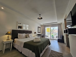 Habitación de hotel moderna con una cama grande, un escritorio, una silla y una televisión.