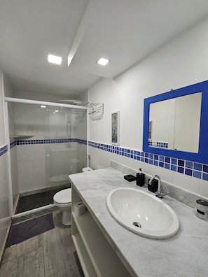 Un baño con ducha, inodoro y lavamanos.