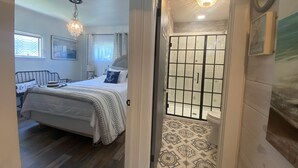 A bedroom with a bed, a bedside table, a hanging light fixture, and a window with curtains. - Cedar Point, Sports Force, Kalahari Near Cottage. Boat Parking ez Walk to Beach! (Huron)