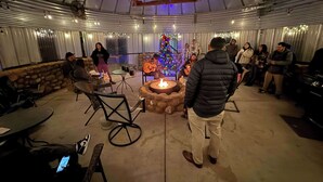 Un espacio interior con una chimenea, asientos y un árbol de Navidad decorado.