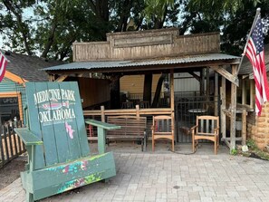 Un área de estar al aire libre rústica con bancos de madera y un letrero que indica Medicine Park en Oklahoma.