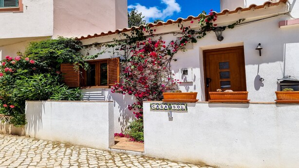 Un bâtiment blanc avec une enseigne indiquant « CASA S.O.S. » et une porte en bois.